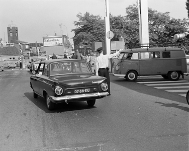 850413 Afbeelding van een verkeersagent die het verkeer regelt bij de Oosterkade te Utrecht, voor de rotonde op het ...